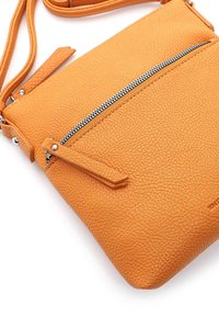 Oranžová texturovaná kožená kabelka přes rameno s přední kapsou na zip a nastavitelným popruhem. Obsahuje stříbrné kování a minimalistický design.