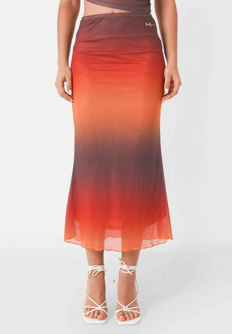 Lång, figurnära kjol i en gradient från orange till röd, tillverkad av ett lätt och genomskinligt tyg. Utsmyckad med en liten logotyp på midjebandet.