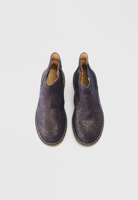 Chaussures slip-on en cuir suédé bleu avec une finition scintillante, dotées de zips latéraux et d'une semelle blanche cousue. L'intérieur est en cuir beige.