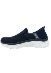 Chaussure bateau bleu marine à enfiler avec dessus en maille, col rembourré et semelle blanche flexible dotée d'accents texturés et d'une étiquette logo sur le côté.