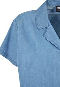 Light blue short-sleeve denim shirt with a notch collar and visible stitching on the sleeve and shoulder.