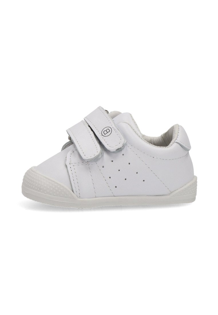 Zapato blanco de cuero con correas de velcro, diseño perforado para transpirabilidad, punta redonda y suela de goma texturizada.