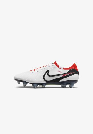 Chaussure de football Nike Tiempo blanche avec Swoosh noir, col montant rouge en maille et crampons transparents sous la semelle pour terrain ferme.