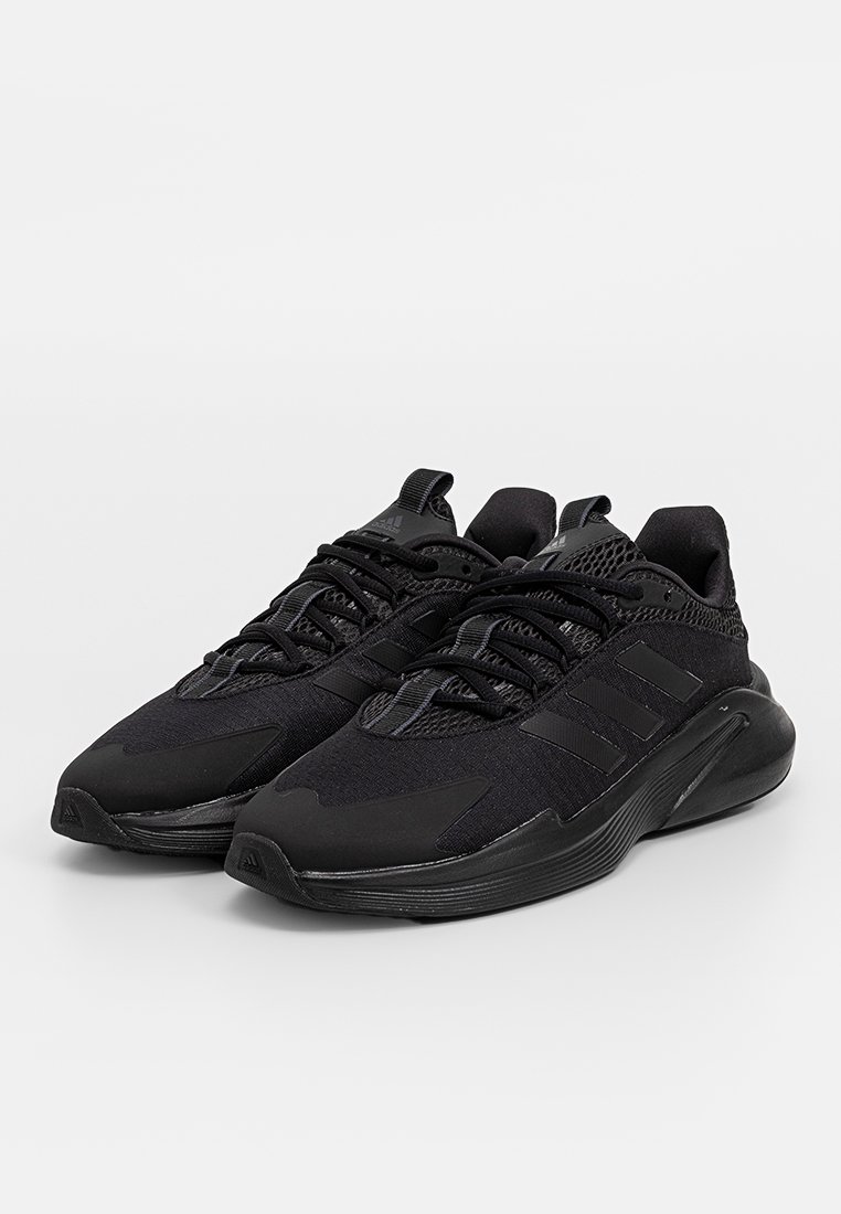 Zapatillas deportivas negras con una parte superior de malla texturizada, suela de goma y un distintivo logo de tres rayas en los lados. Diseño de punta redondeada.
