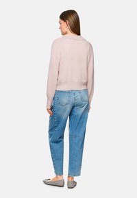 Helles rosa gestricktes Sweatshirt mit Kragen, kombiniert mit lässigen blauen Jeans und grauen Ballerinas. Das Design zeichnet sich durch eine cropped Passform und gerippte Bündchen aus.