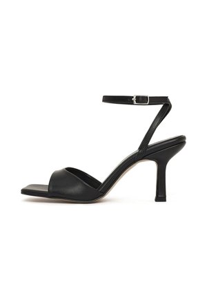 Sandale à talons hauts en cuir noir avec bout carré, bride avant ouverte, fine sangle chevillère avec boucle argentée et talon élancé.