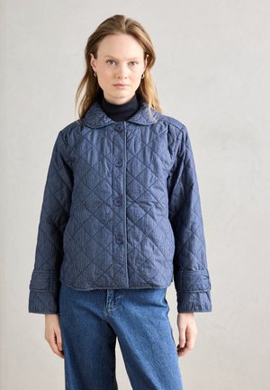 Quilted jakke i mørkeblå med vertikale striper, har store knapper, en rundet krage og mansjetter med oppbrett. Glatt tekstur.