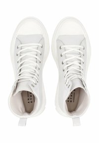 Zapatillas altas blancas de lona con suelas de goma, que cuentan con un diseño de cordones, ojales de metal y lengüetas en la parte trasera.