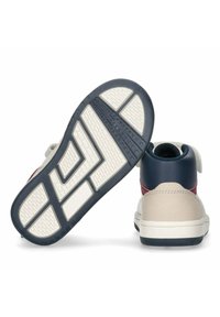 Zapatillas altas con un esquema de color beige, azul y burdeos; suela de goma texturizada con patrones geométricos; aseguradas por una correa ajustable.