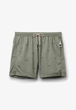 Lichtgroene zwembroek met kleine zwarte haai prints, elastische tailleband, witte aantrekkoord, zijzakken en een metalen flesopener bevestigd.