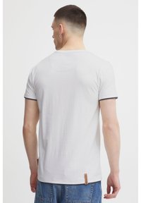 Grey short-sleeved t-shirt with a round neck, featuring dark trim on sleeves and a fabric label at the hem. Smooth texture, casual fit.