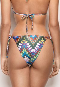Bikini dolne z wysokim krojem. Materiał posiada wielokolorowy geometryczny wzór na teksturowanej tkaninie. Związania po bokach.