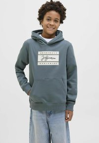 Sudadera con capucha en verde azulado oscuro, que presenta un gráfico central con el logo "Jack Jones" y "Originals Worldwide". Tejido suave, bolsillo tipo canguro.