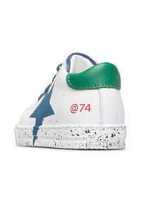 Sneaker bianca con accentuazione verde sul tallone e design di stella blu. Presenta una suola texturizzata e maculata e il dettaglio rosso "@74" sul lato.