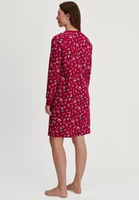 Vestito da notte rosso con maniche lunghe, caratterizzato da un motivo giocoso di uccelli e fiocchi di neve. Materiale morbido con scollatura rotonda e taglio al ginocchio.