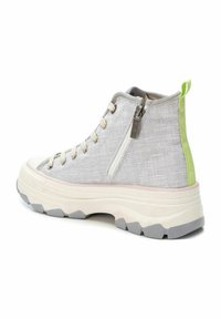 Zapatilla de lona alta en gris claro con un acabado texturizado, con una cremallera lateral, cordones beige y un lazo trasero en verde neón. Suela blanca gruesa.