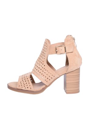 Sandal con tacco in suede beige, con perforazioni ritagliate, cinturino alla caviglia con fibbia e tacco a blocco texturizzato.