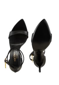 Zwarte leren hoge hakken sandalen met spitse neus, dubbele banden over de voet en enkelband met een gouden hanger detail.