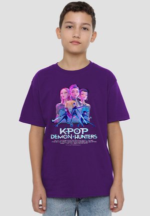 Purple cotton t-shirt featuring a graphic print of characters from "K-POP Demon Hunters" in vibrant colors and stylized text.