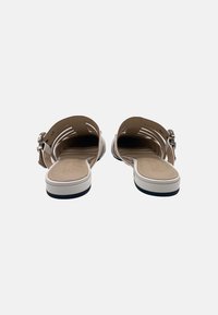Sandali slingback in pelle marrone chiaro con soletta beige imbottita, suola bianca e dettagli in fibbia argentata, caratterizzati da un design aperto sul retro.