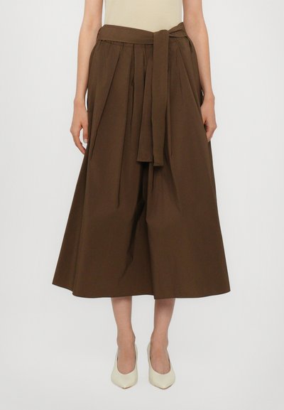 Brown, mid-length skirt made of cotton with a high waist, featuring pleats and a tied fabric belt. Smooth texture and loose fit.