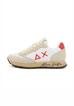 Baskets avec une tige en suède beige et en cuir blanc, accents rouges, logo triangulaire et le texte "Cours plus vite" sur le côté. Semelle en caoutchouc.