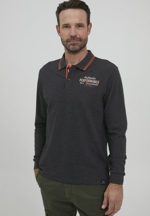 Polo de manga larga en gris oscuro con acentos en color naranja en el cuello y un logo en el pecho. Está hecho de una tela suave, presenta un corte clásico y una tapeta de botones.