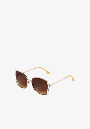 Lunettes de soleil à monture dorée avec verres dégradés marron et branches fines aux extrémités beiges, présentées sur fond blanc.