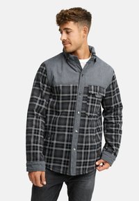 Szary, w kratkę, button-up blezer z denimowym yoke na ramionach, z przednią kieszenią i kontrastującymi szarymi rękawami. Miękki, teksturowany materiał.