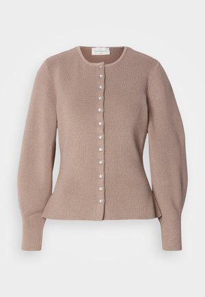 Heledatud kuni 12-18 kuud, nõeltrikoost kangast kardigan heledas pruunis. Ümara kaelusega ja lamedate vormidega. Ees on nööbikinnis ja pärlilaadsed aktsendid.