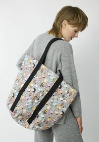 Tote-Bag mit einem Cartoon-Druck von Charakteren in Pastellfarben auf einem grauen Hintergrund. Schwarze Träger und strapazierfähiges Material.