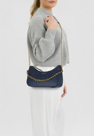 Marineblaue Lederschultertasche mit geprägtem Logo, goldener Kettenriemen und Reißverschluss. Strukturierte Oberfläche und geschwungene Form verbessern das Design.