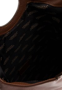 Braune Lederhandtasche mit einem schwarzen Futter, das ein wiederholtes "VENEZIA"-Logo-Muster zeigt. Sie verfügt über eine flache Tasche und hat eine glatte Textur.