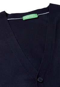 Cárdigan azul marino de cuello en V, hecho de material suave, con cierre de botones y una etiqueta verde con la marca "United Colors of Benetton".