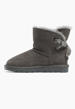 Graue Wildleder-Stiefelette mit faux-fur Innenfutter und Ripsband-Detail. Verfügt über eine flache Gummisohle und eine abgerundete Zehenform. Insgesamt glatte Textur.