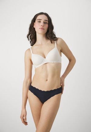 Bh van zachte ivoorkleurige stof met gladde cups, verstelbare bandjes, gecombineerd met marineblauwe slipjes met kantafwerking, met een lage taille.