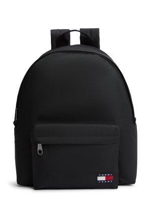 Mochila negra con correas acolchadas, bolsillo frontal con cremallera y parche con el logo de Tommy Jeans en la esquina inferior derecha del bolsillo.