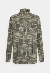 Camo jack in groene tinten, met een hoge kraag, lange mouwen, vier vo pockets en een trekkoord in de taille. Katoenen stof.
