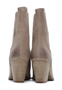 Stivaletti alla caviglia in suede beige con punta arrotondata, pannelli elastici laterali e tacco marrone texturizzato. Il tacco presenta scanalature orizzontali per una migliore aderenza.