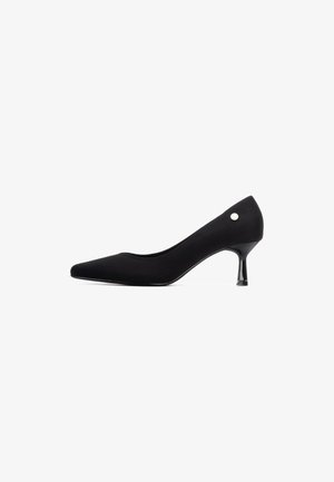 Zapatos de tacón negro de punta afilada con un acabado satinado, que presentan un tacón medio y un acento metálico en la parte trasera. Textura suave y diseño elegante.