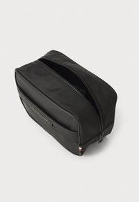 Borsa da toeletta nera realizzata in materiale resistente, con doppia cerniera, forma rettangolare e un sottile accento del logo sulla parte anteriore.