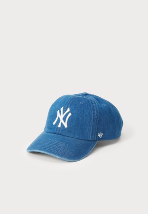 Blue denim baseball cap with white embroidered logo. Features curved brim, adjustable strap, and textured fabric for durability.