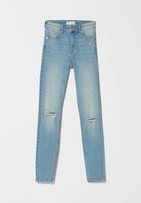Jeans ajustados de un azul claro con un lavado desteñido, que cuentan con dos agujeros desgastados en las rodillas, diseño de cinco bolsillos y cierre de botón metálico.