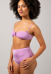 Lila bikiniuppsättning med en rynkad bandeau-topp med ett framklipp och högmidjade underdelar, tillverkad av mjukt, stretchigt tyg.