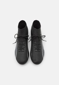 Scarpe da calcio nere con un design elegante e texture, dotate di lacci e di un colletto simile a una calza. Accenti bianchi lungo i lati.