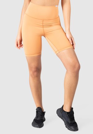 Ferskenfarvede, højtaljede cykelshorts lavet af glat, strækbart stof med kontrasterende sømme, designet til komfort og bevægelighed.