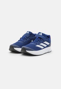 Zapatillas deportivas azul marino con parte superior de malla, tres franjas blancas a los lados, suela de goma y correa de Velcro para un ajuste seguro.