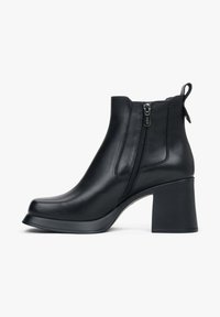Zwarte leren enkelboots met een chunky hak, zijrits, gladde textuur, ronde neus en een trekflap aan de achterkant.