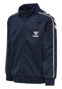 Chaqueta con cremallera de color marino hecha de tejido suave, con rayas laterales blancas, cuello alto y logo de Hummel en el lado izquierdo del pecho. Textura suave.