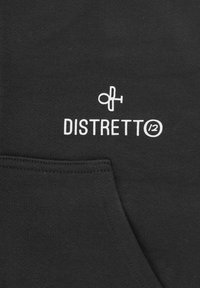 Tessuto di felpa nera con tasca a marsupio. Presenta testo bianco con la scritta "DISTRETTO" e un logo sopra. Texture morbida, design minimale.